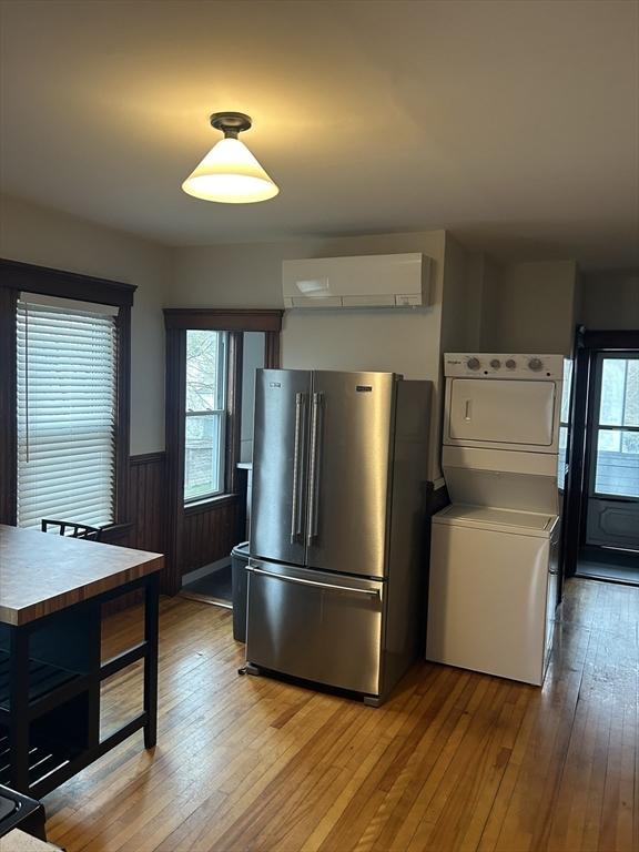 29 Tatman St, Worcester, MA 01607 - kitchen with high end refrigerator, estacked washer and dryer, a wall mounted AC, wainscoting, and plenty of natural light