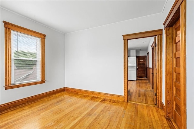 29 Tatman St, Worcester, MA 01607 - empty room featuring hardwood / wood-style floors, baseboards, and stacked washer and clothes dryer