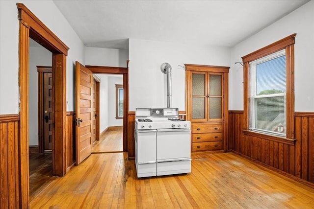 29 Tatman St, Worcester, MA 01607 - kitchen featuring white range with gas cooktop, a wainscoted wall, light wood-style flooring, plenty of natural light, and wood walls