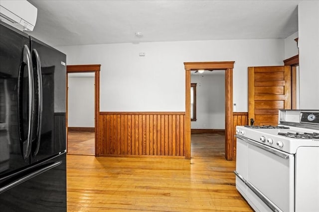 29 Tatman St, Worcester, MA 01607 - kitchen with freestanding refrigerator, white range with gas stovetop, wainscoting, light wood-style flooring, and wooden walls