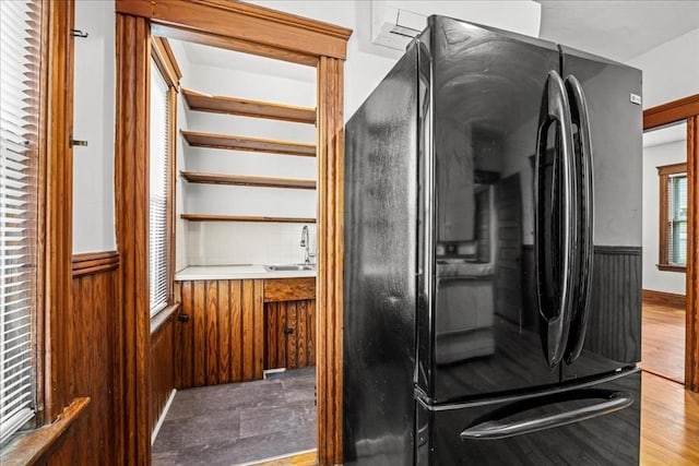 29 Tatman St, Worcester, MA 01607 - detailed view of freestanding refrigerator, wainscoting, a sink, and wood walls