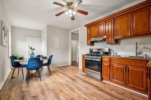 45 Stanley St, Lowell, MA 01850 - kitchen featuring stainless steel gas stove, under cabinet range hood, brown cabinetry, a ceiling fan, and light wood finished floors