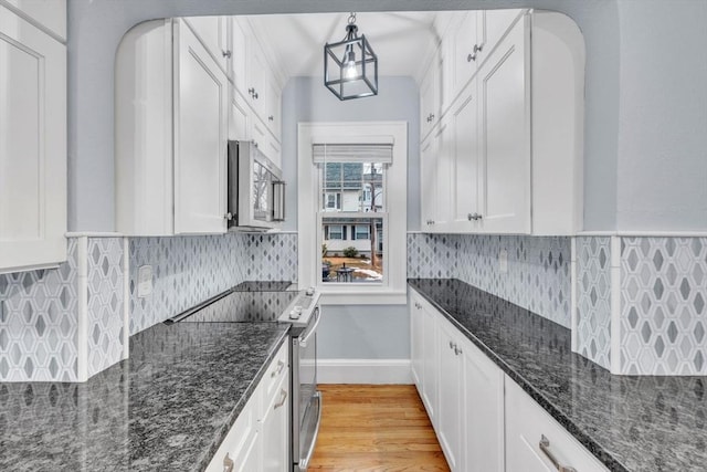 kitchen with dark stone countertops, white cabinetry, and stainless steel appliances