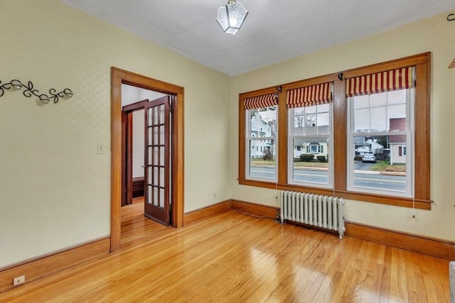 unfurnished room featuring light hardwood / wood-style floors and radiator