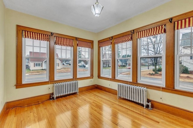 unfurnished sunroom with radiator heating unit