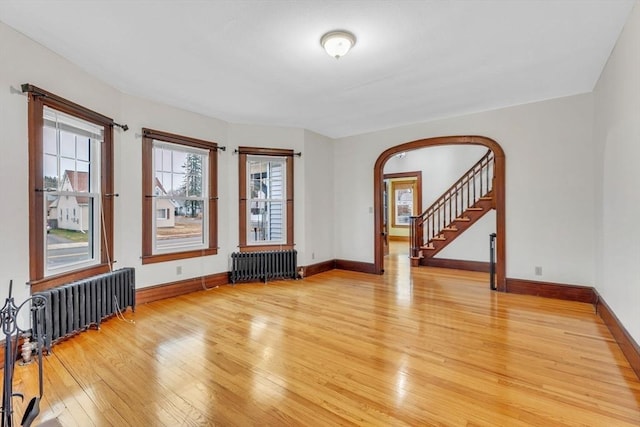 empty room featuring radiator heating unit and light hardwood / wood-style floors