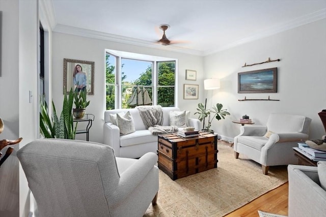 living room featuring ornamental molding, ceiling fan, and light wood-type flooring