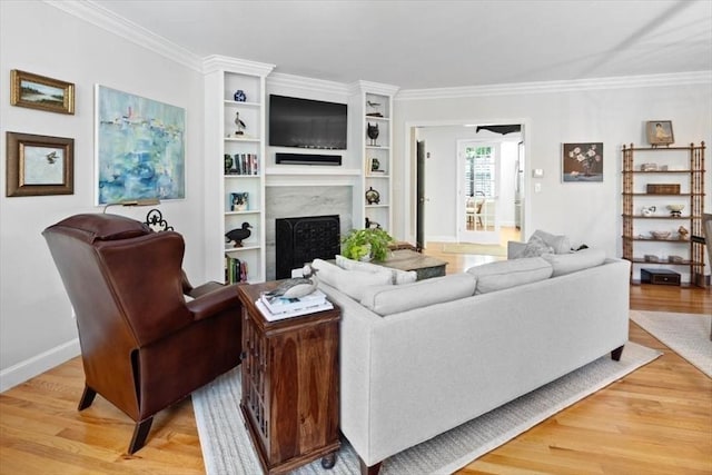 living room with crown molding, a fireplace, and light hardwood / wood-style flooring