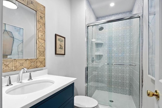 bathroom featuring an enclosed shower, vanity, and toilet