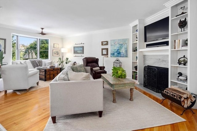 living room featuring hardwood / wood-style flooring, a premium fireplace, and ornamental molding