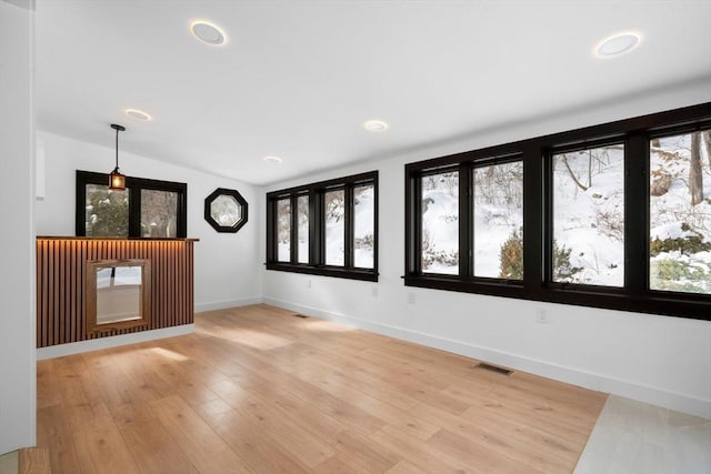 spare room featuring hardwood / wood-style flooring and lofted ceiling