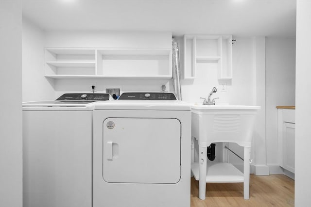 laundry room featuring washer and clothes dryer and light hardwood / wood-style flooring