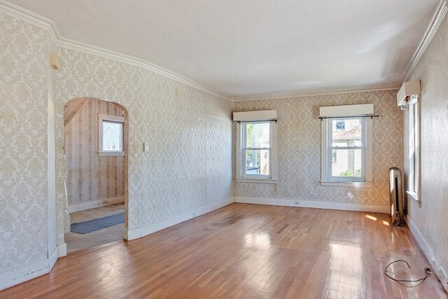 unfurnished room with wood-type flooring, crown molding, and baseboards