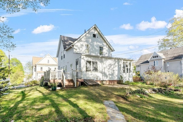 back of property featuring a lawn and a wooden deck