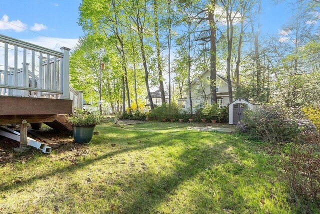 view of yard with a storage shed, a deck, and an outdoor structure
