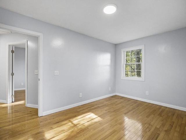 spare room featuring light wood-style floors and baseboards