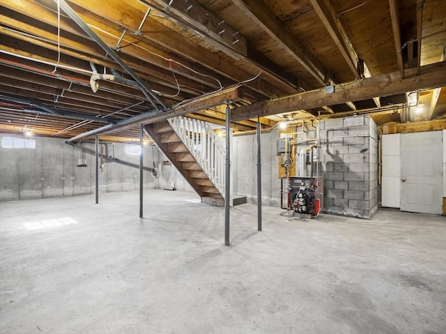 below grade area featuring a heating unit and stairs