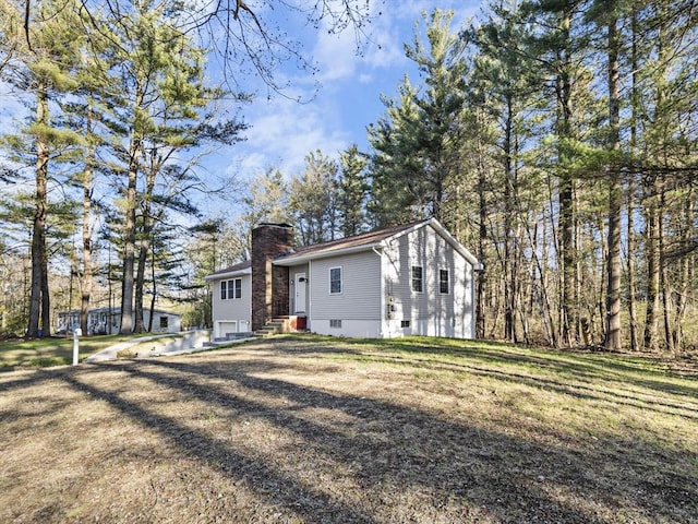 exterior space with a front yard, a chimney, and entry steps