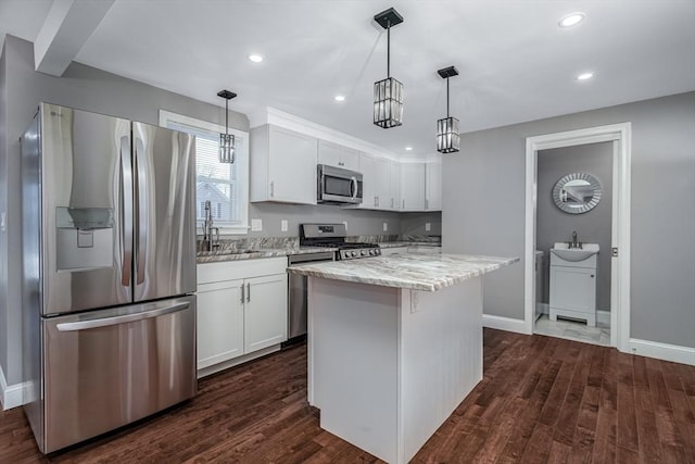 70 Sanborn St, Fitchburg, MA 01420 - kitchen featuring appliances with stainless steel finishes, a sink, white cabinets, light stone counters, and dark wood-style floors
