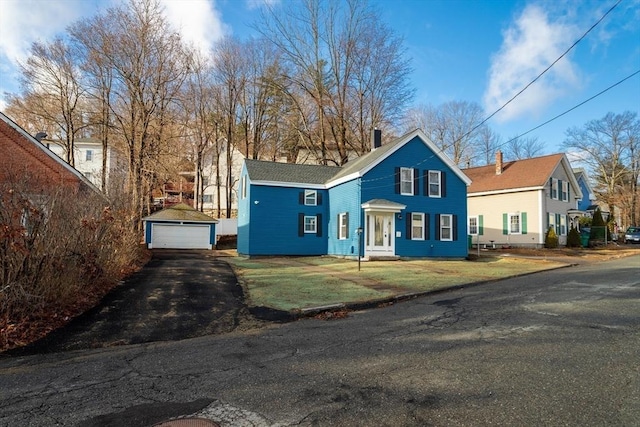 70 Sanborn St, Fitchburg, MA 01420 - view of front of property with a garage, an outdoor structure, a front lawn, and a chimney