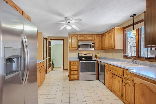 kitchen with pendant lighting, sink, stainless steel appliances, and light tile patterned flooring