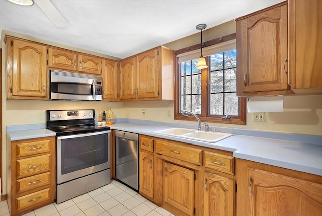 kitchen with stainless steel appliances, sink, light tile patterned floors, and decorative light fixtures