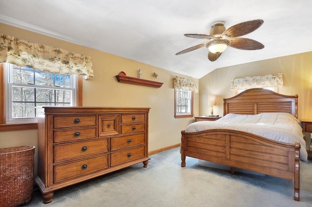 carpeted bedroom featuring multiple windows, vaulted ceiling, and ceiling fan