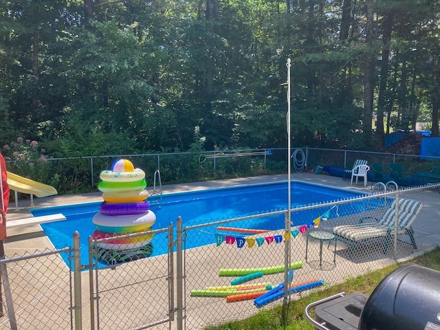 view of pool with a diving board