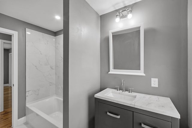 bathroom with tiled shower / bath and vanity