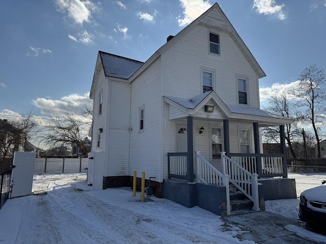 view of front facade featuring a porch and fence