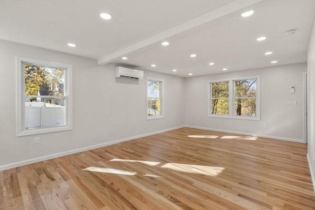 unfurnished room with recessed lighting, a wall mounted AC, and baseboards