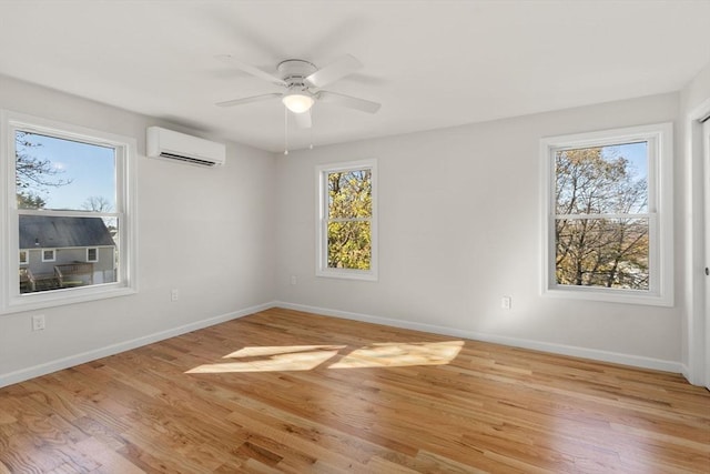 empty room featuring baseboards, a ceiling fan, light wood-style floors, and an AC wall unit
