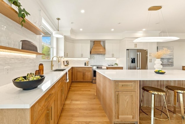 3 Colburn St Unit 1, Gloucester, MA 01930 - kitchen featuring appliances with stainless steel finishes, premium range hood, a breakfast bar, light countertops, and tasteful backsplash