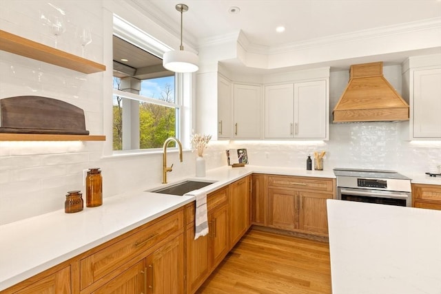 3 Colburn St Unit 1, Gloucester, MA 01930 - kitchen with premium range hood, light countertops, backsplash, crown molding, and recessed lighting