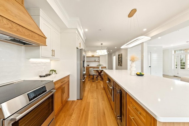 3 Colburn St Unit 1, Gloucester, MA 01930 - kitchen featuring stainless steel appliances, premium range hood, light wood-style floors, a large island, and white cabinets
