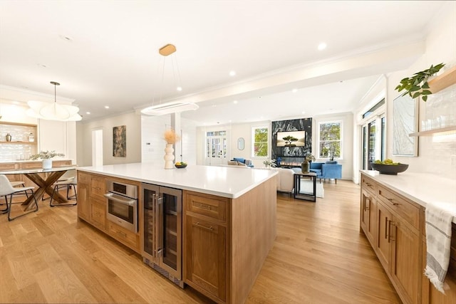3 Colburn St Unit 1, Gloucester, MA 01930 - kitchen with wine cooler, light wood-style floors, recessed lighting, light countertops, and ornamental molding