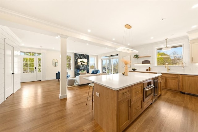 3 Colburn St Unit 1, Gloucester, MA 01930 - kitchen featuring open floor plan, a breakfast bar, light wood finished floors, crown molding, and recessed lighting