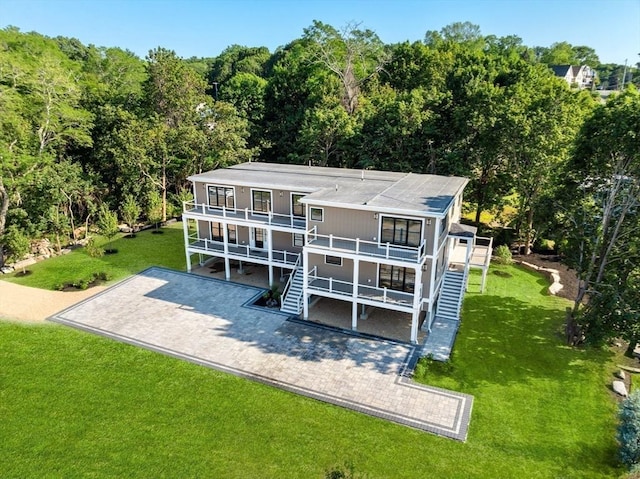 3 Colburn St Unit 1, Gloucester, MA 01930 - back of property featuring a balcony, a forest view, a yard, and stairs