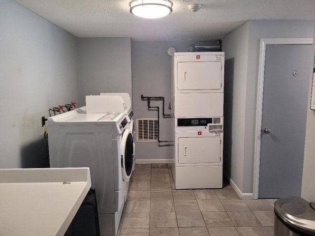 5 Hallmark Gdns Unit 6, Burlington, MA 01803 - shared laundry room with stacked washer / drying machine, a textured ceiling, and light tile patterned floors