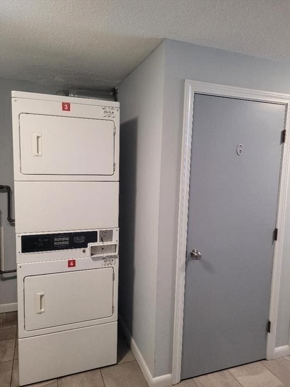 5 Hallmark Gdns Unit 6, Burlington, MA 01803 - washroom featuring stacked washing machine and dryer, light tile patterned floors, and a textured ceiling