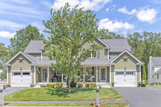 1 Woodland Ct Unit B, Milford, MA 01757 - view of front facade with asphalt driveway, covered porch, roof with shingles, a front yard, and a garage