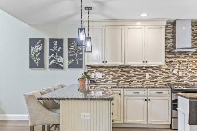 1 Woodland Ct Unit B, Milford, MA 01757 - kitchen with wall chimney exhaust hood, stainless steel range with gas stovetop, a breakfast bar, backsplash, and dark stone countertops