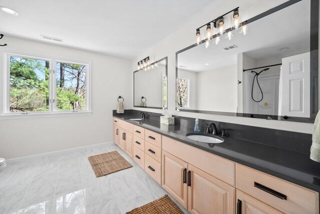 65 Sheffield Ter, Marlborough, MA 01752 - full bath featuring baseboards, double vanity, marble look tiles, toilet, and a shower