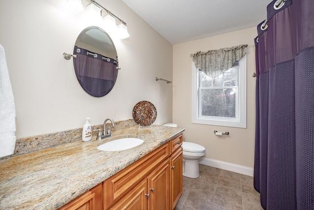 bathroom with tile patterned flooring, vanity, and toilet