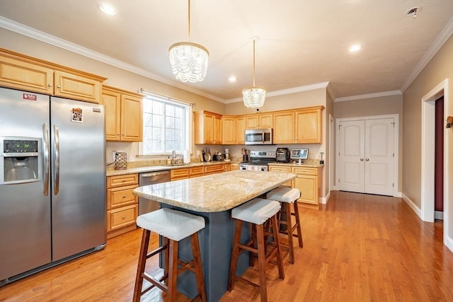 kitchen with a center island, hanging light fixtures, an inviting chandelier, light hardwood / wood-style floors, and appliances with stainless steel finishes