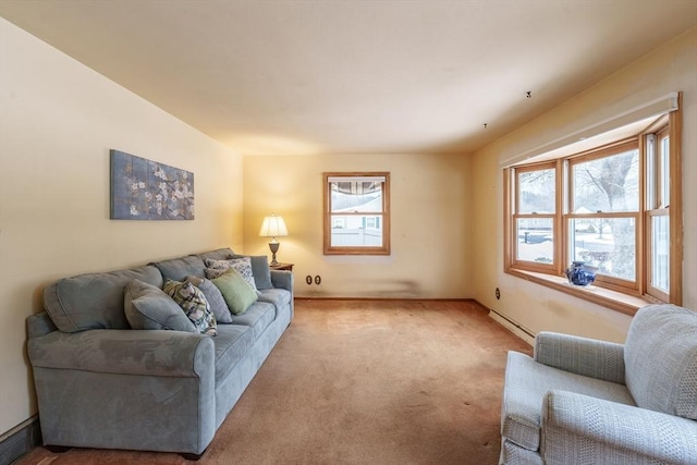 living area with a baseboard heating unit, carpet flooring, and baseboards