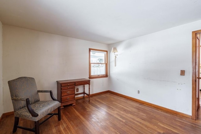 living area featuring hardwood / wood-style flooring and baseboards