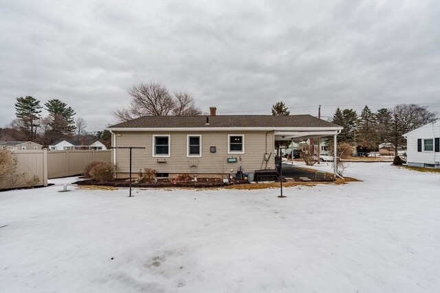 snow covered property with fence and a chimney