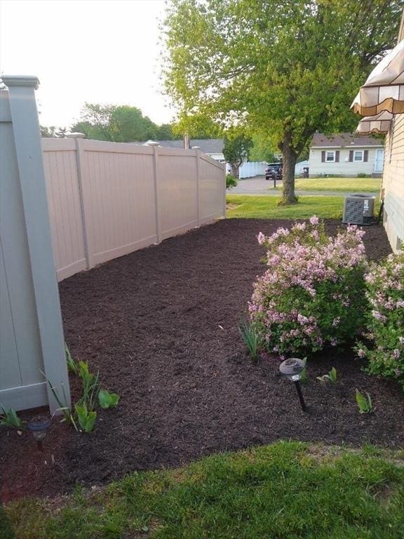 view of yard featuring cooling unit and fence