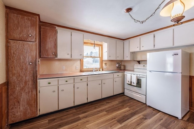 kitchen with white appliances, a sink, and white cabinets